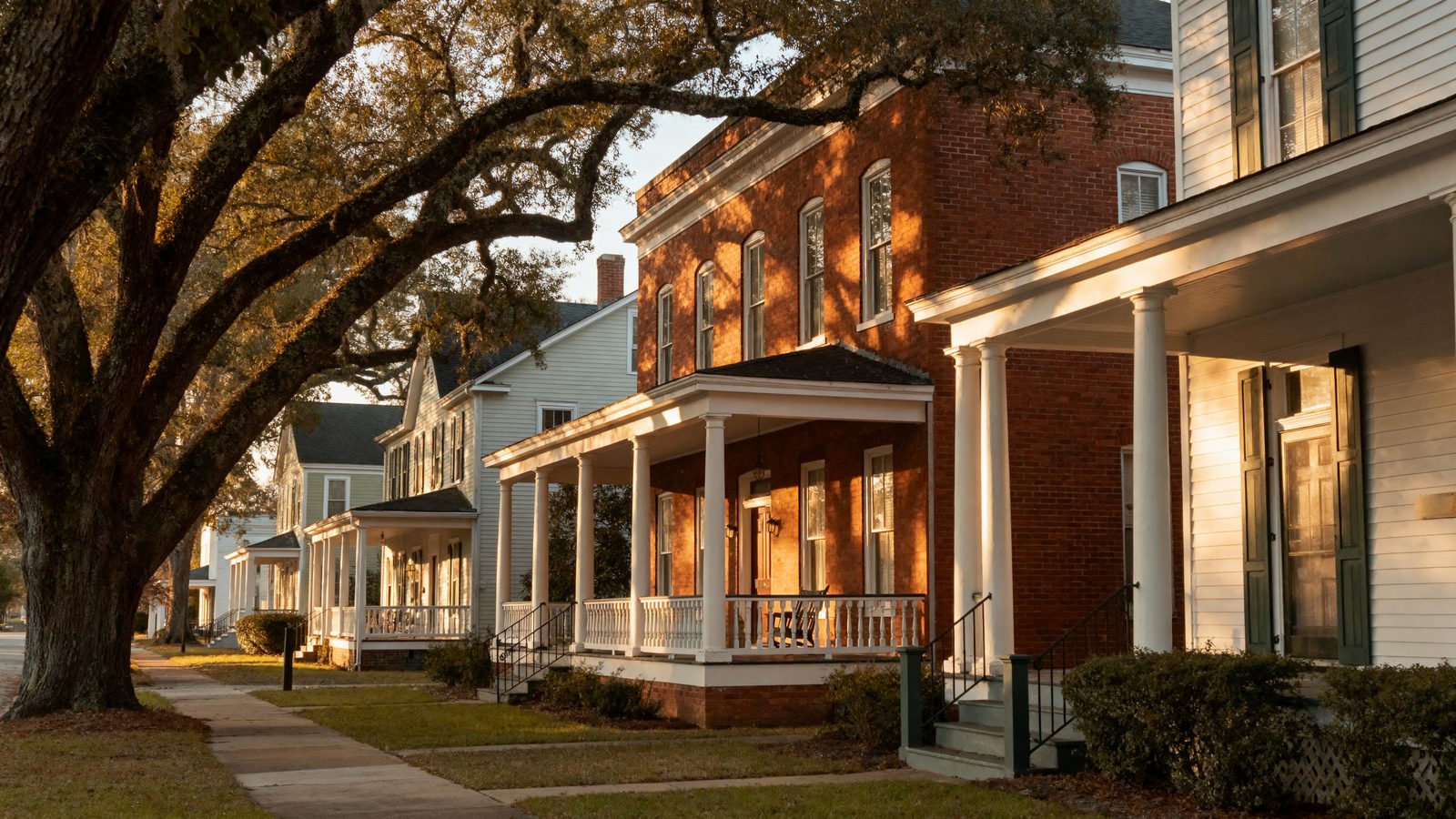 A tree-lined street of historic brick and clapboard homes with deep front porches in Concord, North Carolina